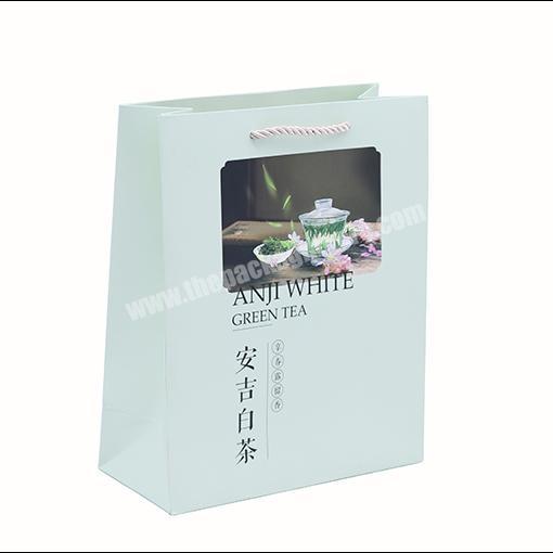 China Factory light-green tea packaging handle paper bag custom opening window paper carrier bag with matt laminated