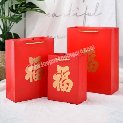 New year custom red paper bags on sale, best price cheap paper shopping carrier gift bags made in China