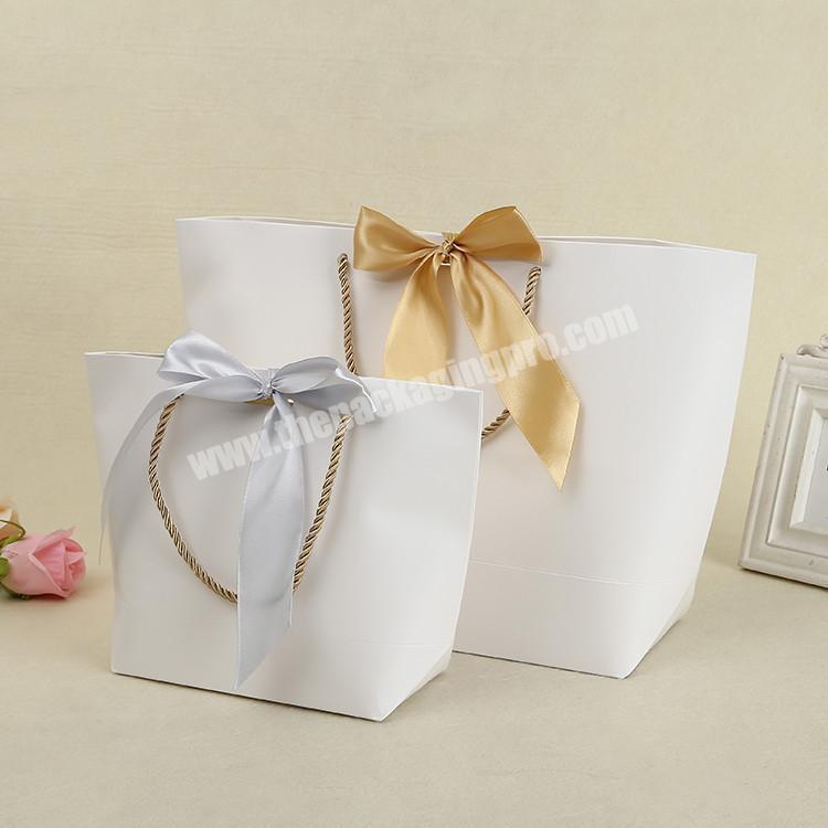 Customer raw material folding shopping paper bag with gold ribbon bow tie