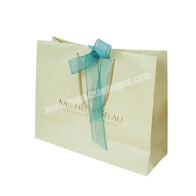 Elegant yellow paper make up products shopping bag with blue ribbon bow tie