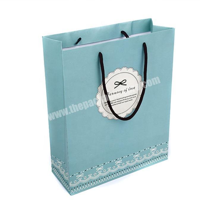 Luxury paper shopping bag with rope handle and ribbon bow for retail store