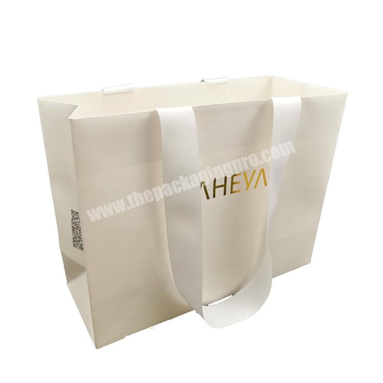 Hot sales Recyclable hot stamping custom logo print paper bags spot printing white shopping paper bag with ribbon