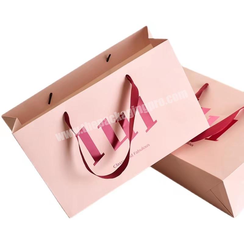 Wholesale luxury paper bags with your own logo custom hot stamping gift bag reusable pink shopping bag with ribbon handle